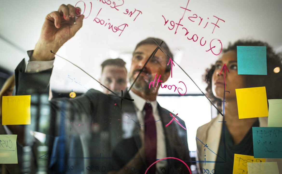 Businesspeople planning on a glass wall