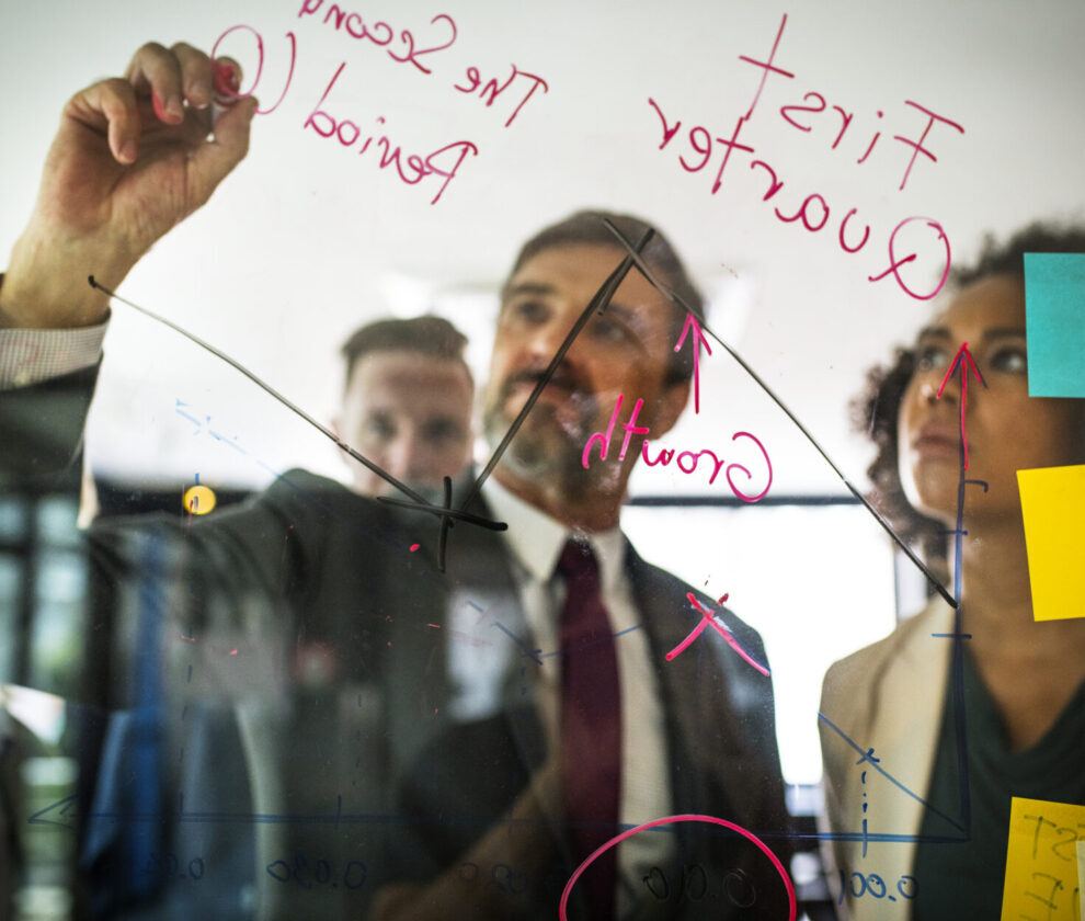 Businesspeople planning on a glass wall